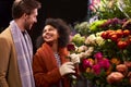 Couple Choosing Flowers From Florist Stall At Outdoor Christmas Market Royalty Free Stock Photo