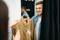 Couple choosing shirts in fitting room, store