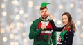 Couple with christmas party props in ugly sweaters Royalty Free Stock Photo