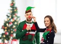 Couple with christmas party props in ugly sweaters Royalty Free Stock Photo