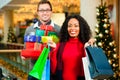 Couple with Christmas presents and bags in mall Royalty Free Stock Photo