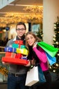 Couple with Christmas presents and bags in shoppin Royalty Free Stock Photo