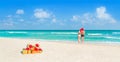 Couple in Christmas Santa hats at beach with holiday gifts Royalty Free Stock Photo