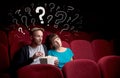 Couple in cinema with questions Royalty Free Stock Photo