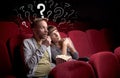 Couple in cinema with questions Royalty Free Stock Photo