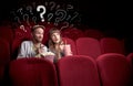 Couple in cinema with questions Royalty Free Stock Photo