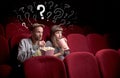 Couple in cinema with questions Royalty Free Stock Photo