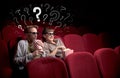 Couple in cinema with questions Royalty Free Stock Photo