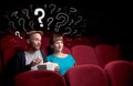 Couple in cinema with questions Royalty Free Stock Photo