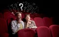 Couple in cinema with questions Royalty Free Stock Photo