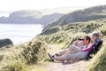 Couple on cliffside outdoors using binoculars Royalty Free Stock Photo