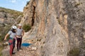 Couple of climbers prepare the knots in their harness to start climbing. They are both happy and smiling