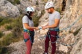 Couple of climbers with their hands almost together securing the eight knot of the harness before starting rock climbing