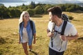 Couple Climbing Hill On Hike Through Countryside In Lake District UK Together