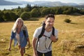 Couple Climbing Hill On Hike Through Countryside In Lake District UK Together