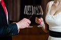 Couple clink glasses with red wine at meeting or wedding