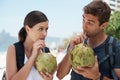 Couple, coconut and drink at beach in summer for vacation with milk, cocktail and juice on journey. People, man and Royalty Free Stock Photo