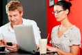 Couple in coffeeshop with laptop and mobile Royalty Free Stock Photo