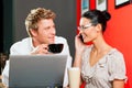 Couple in coffeeshop with laptop and mobile