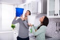 Couple Collecting Water Leaking From Ceiling In Bucket Royalty Free Stock Photo