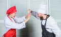 Couple compete in culinary arts. Kitchen rules. Who cook better. Culinary battle concept. Woman and bearded man culinary Royalty Free Stock Photo