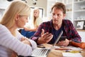 Couple with computers arguing in the kitchen Royalty Free Stock Photo