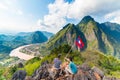 Couple conquering mountain top at Nong Khiaw panoramic view over Nam Ou River valley Laos national flag scenic mountain landscape Royalty Free Stock Photo