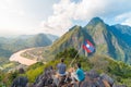 Couple conquering mountain top at Nong Khiaw panoramic view over Nam Ou River valley Laos national flag scenic mountain landscape Royalty Free Stock Photo