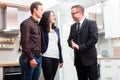 Couple consult salesman for domestic kitchen Royalty Free Stock Photo