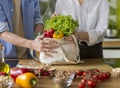 Couple cook on cozy kitchen, husband helps young wife to prepare dinner