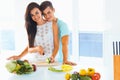 Couple cooking healthy food and smiling at the camera. Lifestyle Royalty Free Stock Photo