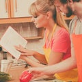 Couple cooking in kitchen reading cookbook Royalty Free Stock Photo