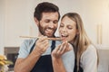 Couple, cooking and taste test in kitchen with romance, support and love in their home together. Food, spoon and man Royalty Free Stock Photo