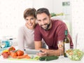 Couple cooking together and using a tablet