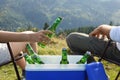 Couple and cool box with bottles of beer in nature, closeup Royalty Free Stock Photo