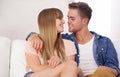 Couple, couch and kiss for love, hold and smile in home together for romance with connection. Woman, man and sit on sofa Royalty Free Stock Photo