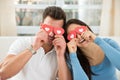 Couple covering eyes with the red hearts