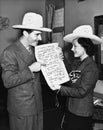 Couple with cowboy hats looking at sheet music Royalty Free Stock Photo
