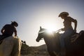 Couple of cowboy ride horses with sunflare Royalty Free Stock Photo