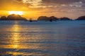 Couple of cruise philippinean bangca boats standing still on water with sunset and tropical islands in background, Palawan,