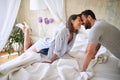 Couple cuddling in the morning while making the bed. bedroom, morning, togetherness, romance concept