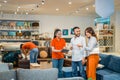 couple customers chat with a female store employee using a tablet