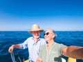 Couple of cute mature people or senior ejoying and having fun together in the middle of the sea or ocean with a small boat or