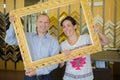 Couple in cute picture holding wooden frame