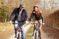 Couple On Cycle Ride In Winter Countryside