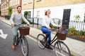 Couple Cycling Along Urban Street Together