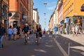 A couple cycling at a pedestrian city shopping street.