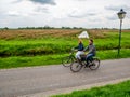 Couple cyclist on bike path in Zaanse Schans. The Zaanse Schans is a typically Dutch small village in Amsterdam, Netherlands.