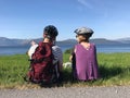 Couple of cyclists are sitting on a meadow