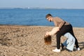 The couple is dancing, having fun and fooling around on the beach. A young bearded man in sunglasses hugs a girl by the Royalty Free Stock Photo